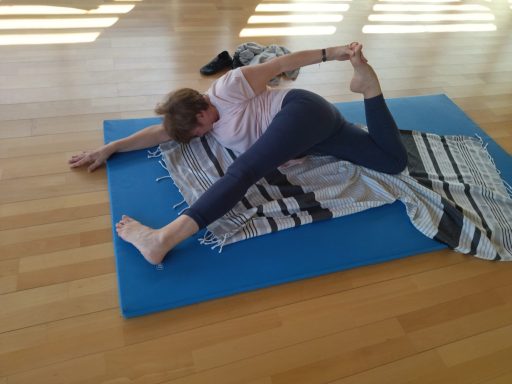 Travail d'assouplissement des membres inférieurs en cours de stretching yoga