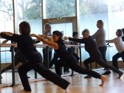 Exercices d'assouplissements à la barre en cours collectif de stretching